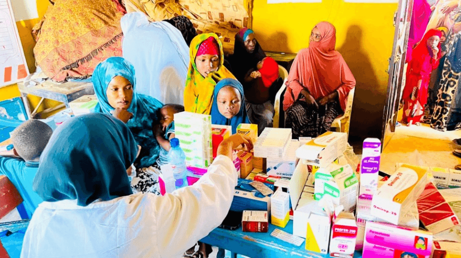 Health worker distributing medicines and supplies to women and children in a community clinic